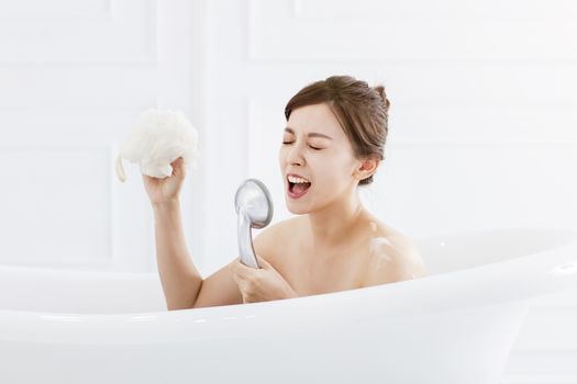  young woman take a bath and singing in the bathtub
