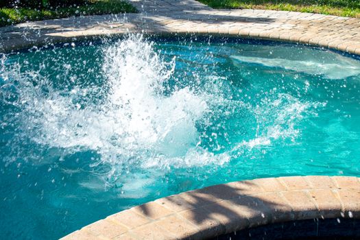 A Splash in a Pool Caused By a Boy Jumping Into the Water