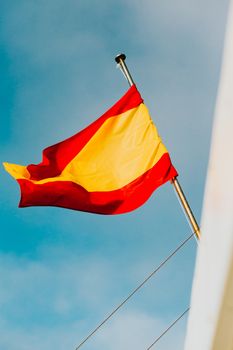 Spanish flag waving with a bright blue sky as the background