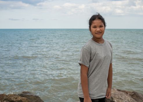 Portrait of a girl standing with a sea background.