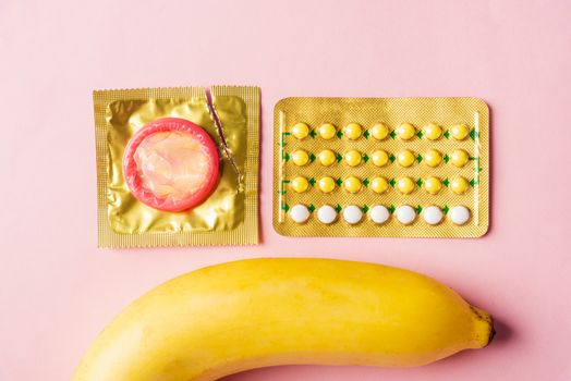 condom on wrapper pack, banana and contraceptive pill