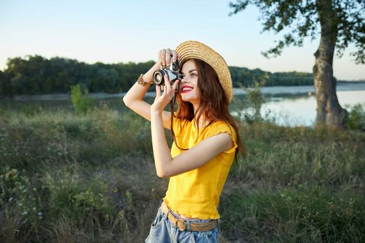 Woman photographer looks into the camera lens smile nature fresh air lifestyle. High quality photo