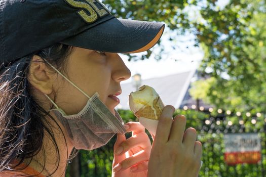 A young girl of Caucasian appearance eats an ice cream cone in a