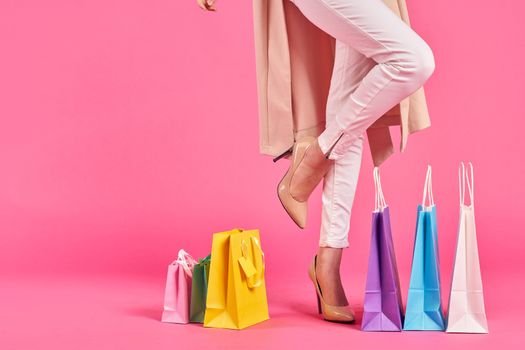 shopping bags female feet in shoes Shopaholic pink background