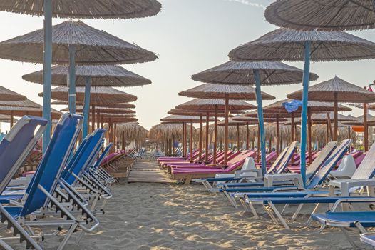 Beach with umbrellas and sunbeds without tourists