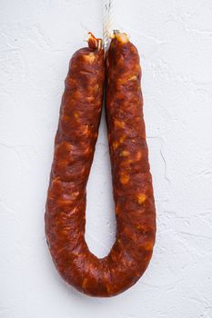 Dry cured chorizo sausage on white textured background