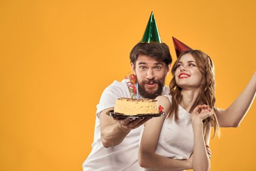Party man and woman with cake cap birthday celebration. High quality photo