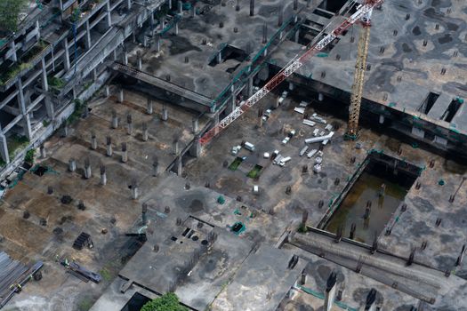 Top view of the construction site of a large building after rain. Piles are driven in and the lower floors are built.