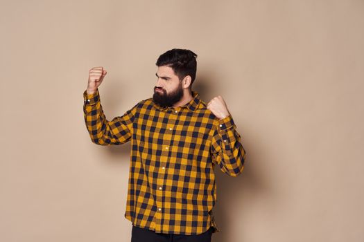 Bearded man in a plaid shirt holds his hands in front of him emotions