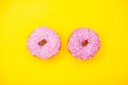 pink delicious donuts on a yellow background