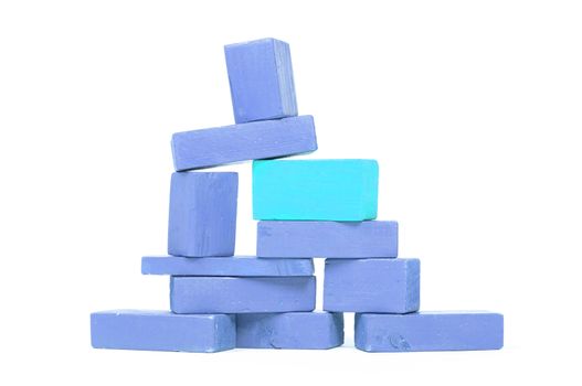 Vintage blue building blocks isolated on white, one standing out