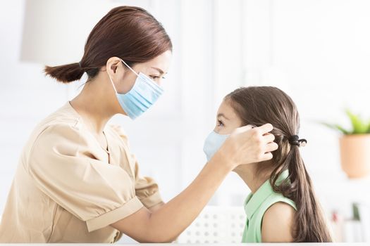 mother help her daughter wearing healthy face mask 