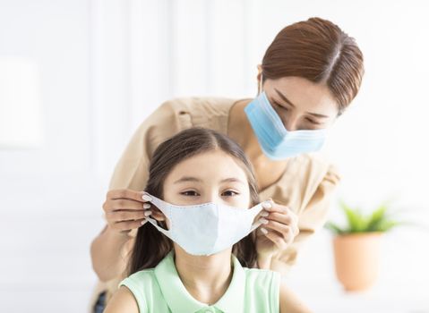 mother help her daughter wearing healthy face mask 