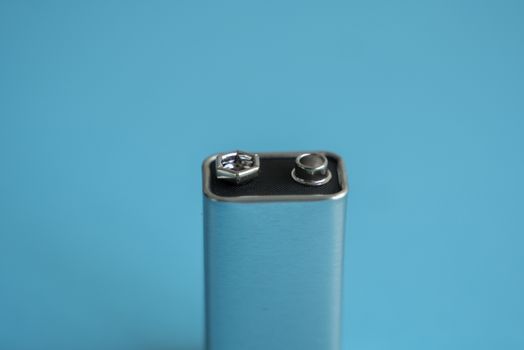 High voltage battery on a blue background. Silver Volt battery. 9V Advanced Lithium Batteries.