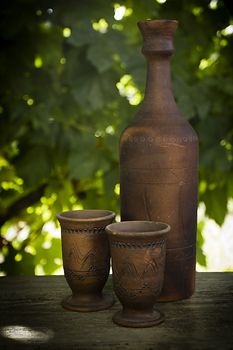 Wine in a clay bottle and glasses outdoors