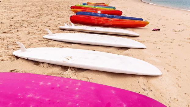Surfboards And Kayaks On A Sandy Beach For Tourists To Hire