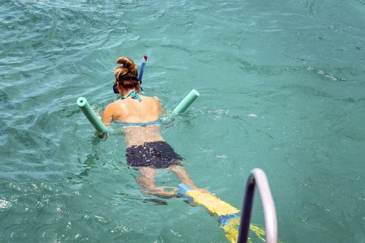 Female Begins To Swim Away From The Boat To Begin Snorkeling