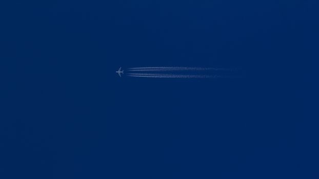 A Jet Plane Leaving A Vapor Trail In The Blue Sky