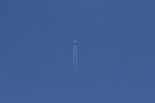 A Jet Plane Leaving A Vapor Trail In The Blue Sky