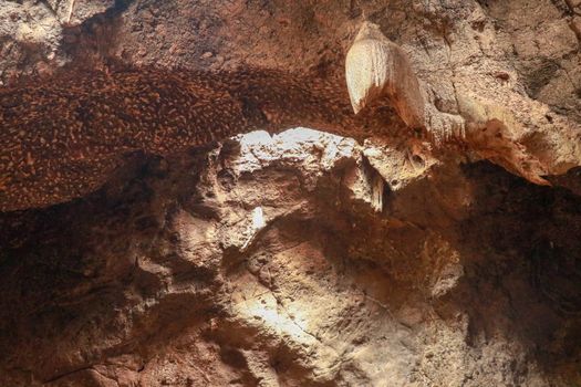 Stalactites hanging from the ceiling of the cave underground. Mountain nature. Habitat of bats. Fallen cave ceiling. A hole in the ceiling of the cave