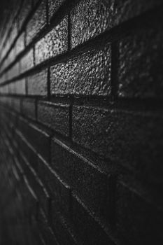 Black and white moody background of a brick wall with texture and copy space