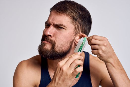bearded tshirt man massaging ear grimace