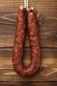 Spicy chorizo bratwurst sausage on light wooden background, flat lay