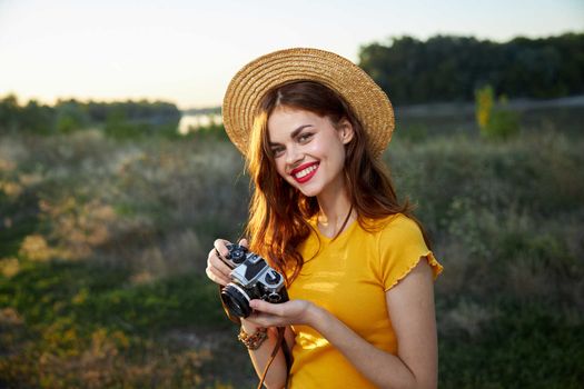 Smiling woman with camera in hands nature travel lifestyle hobby. High quality photo