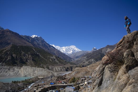 Trekker on cliff looking at view of mountain, Annapurna Conserva
