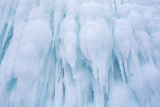 Blue ice stalactite on cliff 