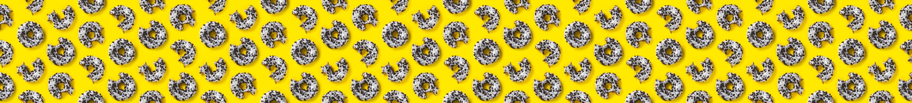 banner donuts on a yellow background top view. Flat lay of delicious nibbled chocolate donuts. used as donut banner or poster background, not pattern.