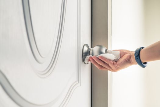 Cleaning door knob with alcohol spray for Covid-19 Coronavirus p