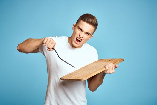 energetic guy with wooden kitchen board and spatula fun emotions