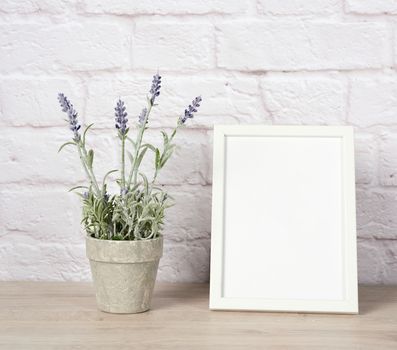 empty white wood frame and lavender pot on shelf, white brick wa