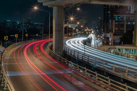 Overpass of the light trails with Bangkok city background at nig