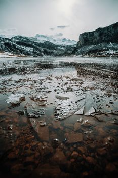 Frozen water and pieces of ice in a frozen lake in the middle of the mountains during winter
