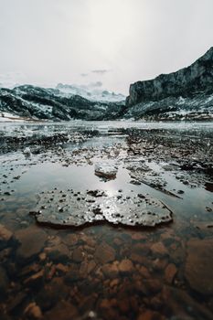 Frozen water and pieces of ice in a frozen lake in the middle of the mountains during winter