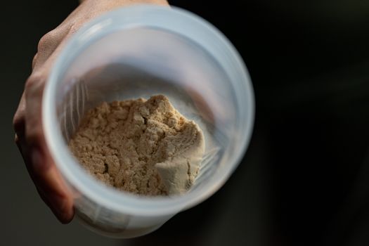 Close up of whey protein and bottle preparing protein shake.