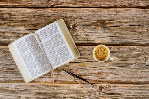 Open Bible morning readings on a table top with coffee cup and eyeglasses