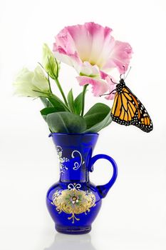 A Monarch Butterfly Hanging From A Flower In A Vase