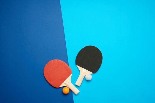 wooden rackets for playing table tennis and a net on a blue back