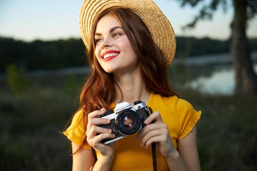 Cheerful woman in nature with a camera leisure hobby lifestyle. High quality photo
