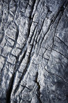 abstract background detail of a dark limestone structure with grooves