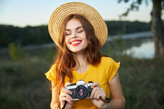 Smiling woman with camera in hands nature travel lifestyle hobby. High quality photo