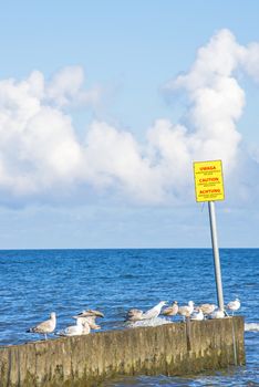 Groin in the Baltic Sea with danger sign