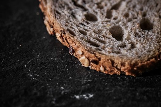Fresh whole grain seeded bread, organic wheat flour, closeup slice texture as background for food blog or cook book recipe