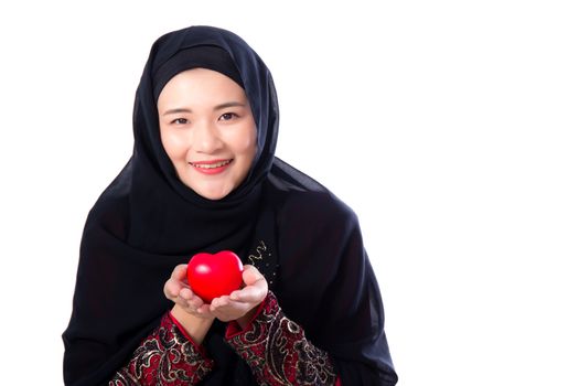 Portrait of young asian muslim woman holding red heart shaped pi