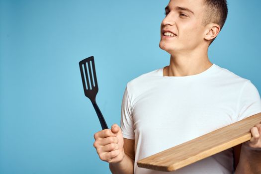 energetic guy with wooden kitchen board and spatula fun emotions