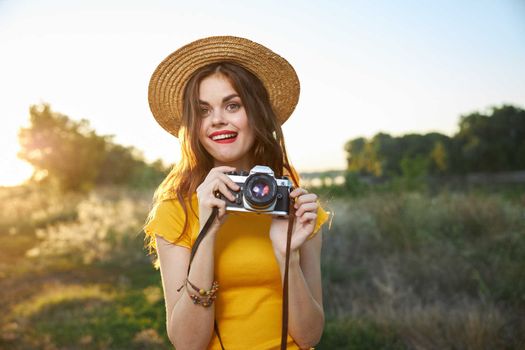 pretty woman holding camera in hands nature fresh air lifestyle. High quality photo