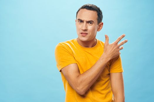 An indignant man gestures with his hands on a blue background